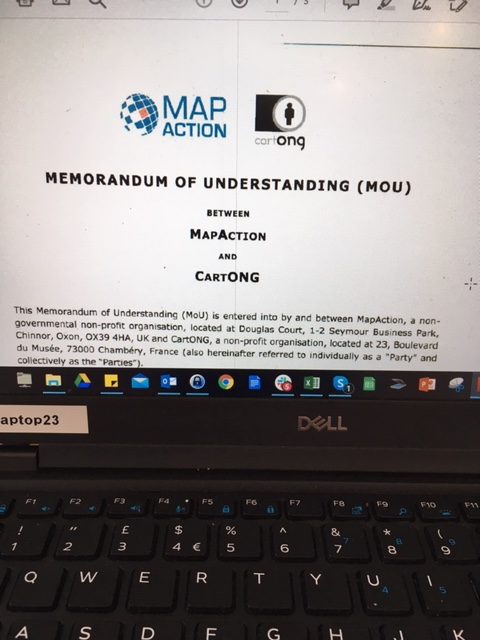 Laptop screen displaying the front page of the MoU with MapAction and CartONG logos visible